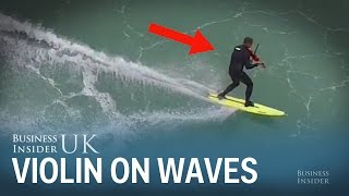 A musician played the violin while surfing milehigh waves in Portugal [upl. by Ellertal]