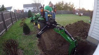 Compact Tractor Backhoe digs hole for basement egress window [upl. by Ellevehs850]